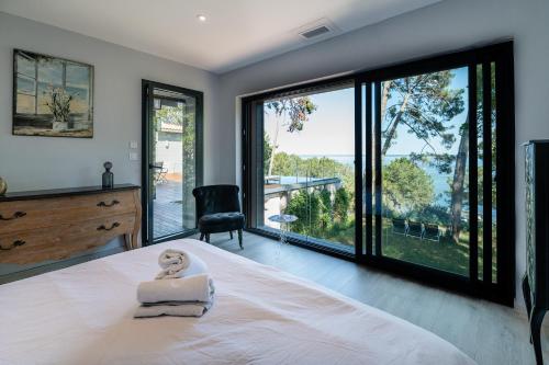 ビスカロッスにあるVilla-SONNIER-Biscarrosseのベッドと大きな窓のある寝室