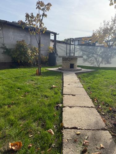 um caminho de pedra que leva a um parque com um banco em Kitti Kuckója em Debrecen