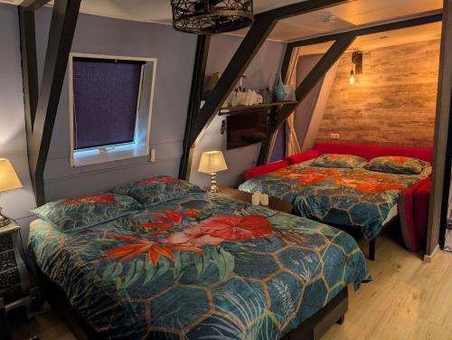 a bedroom with two beds and a window at Het Zwanenest in Harlingen