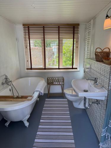 a bathroom with a tub and a sink and a bath tub at Südfrankreich bei Berlin in Werder