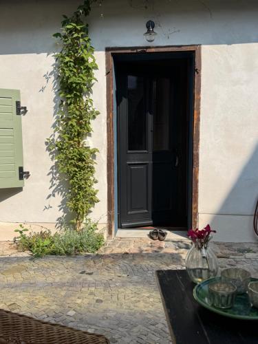 a black door with a table in front of a house at Südfrankreich bei Berlin in Werder