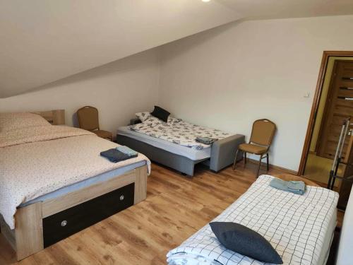 a bedroom with two beds and two chairs in it at Dom Weselny Izabela Noclegi in Osiek