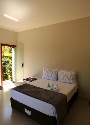a bedroom with a large bed with two dishes on it at Pousada Dona Tereza in Guapé
