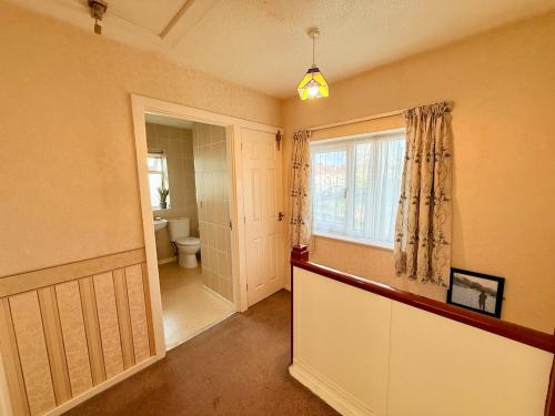 Un baño con inodoro y ventana. en A Perfect Work Base & Family House in Fishpoads, en Bristol