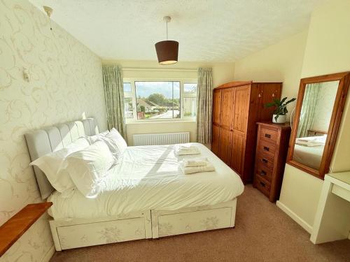 Un dormitorio con una cama blanca y una ventana. en A Perfect Work Base & Family House in Fishpoads, en Bristol