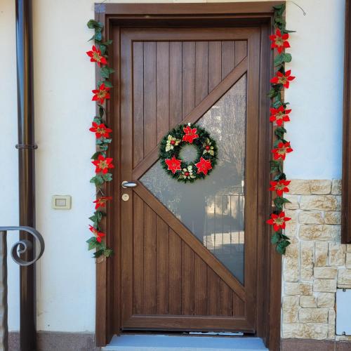 Una puerta de madera con una corona de flores encima. en Villa Dall'Angelo Suite Mountain Lake Endine Hospitality, en Endine Gaiano