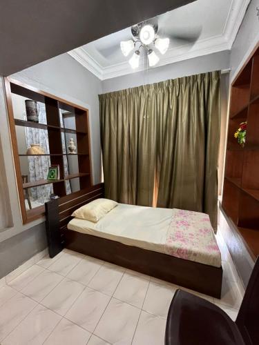 a bedroom with a bed with a ceiling fan and a window at Kota Puteri Vibe Kampung Homestay in Batu Arang