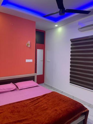 a bedroom with a bed with pink sheets and a blue ceiling at Rainbow apartments in Cochin