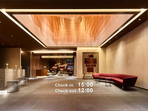 a lobby with a red couch and a table at Mitsui Garden Hotel Roppongi Tokyo Premier in Tokyo