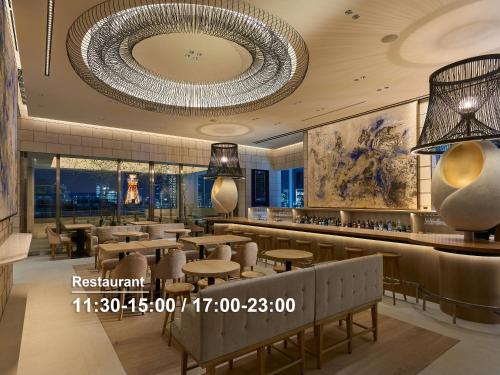 a restaurant with a large chandelier and tables and chairs at Mitsui Garden Hotel Roppongi Tokyo Premier in Tokyo