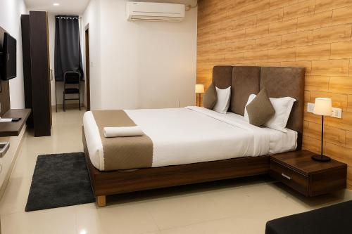 a bedroom with a large bed and a television at Vinayaka in Patna