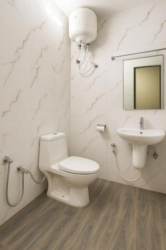 a bathroom with a toilet and a sink at Vinayaka in Patna
