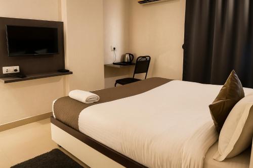 a hotel room with a bed and a television at Vinayaka in Patna