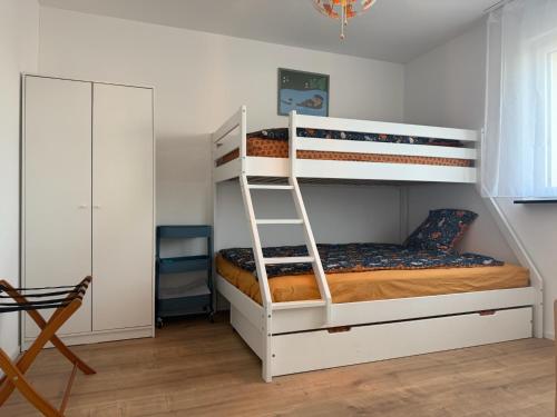 Μία ή περισσότερες κουκέτες σε δωμάτιο στο Moderne Familienwohnung mit Garten & E-Ladestation