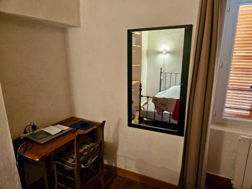 a mirror in a room with a table and a bed at Maison de charme avec Terrasse vue sur mer in Rogliano
