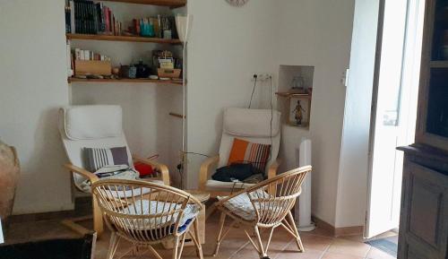 a room with three chairs and a table and a laptop at Maison de charme avec Terrasse vue sur mer in Rogliano