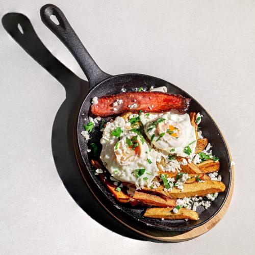 una sartén con una salchicha y patatas fritas en Casa Weidner Hotel Sibiu, en Sibiu