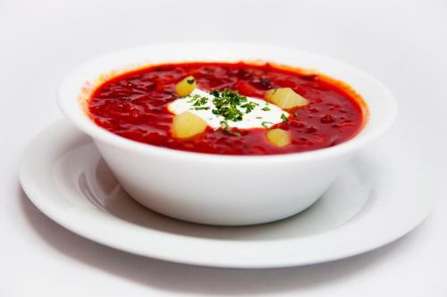 a white bowl of soup on a white plate at Motel Skalka in Radola