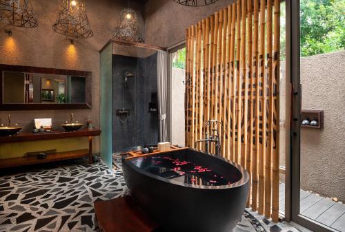 a bathroom with a black bath tub in a room at Keemala in Kamala Beach