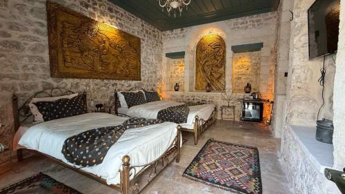 a bedroom with two beds and a fireplace at Liora Hotel in Sanlıurfa