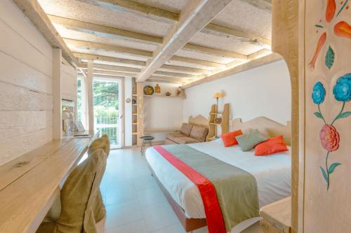 een slaapkamer met een groot bed en een bank bij Relais du Bois Saint Georges - Hôtel de Charme in Saintes