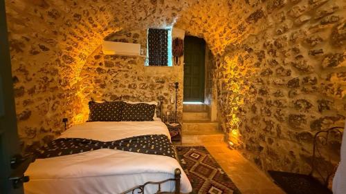 a bedroom with two beds in a stone wall at Liora Hotel in Urfa