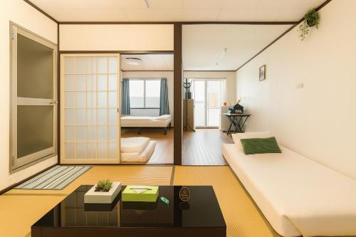 a living room with a couch and a table at Nippori Osaka Nishi-Tengachaya Guesthouse西天下茶屋アパートメント in Osaka