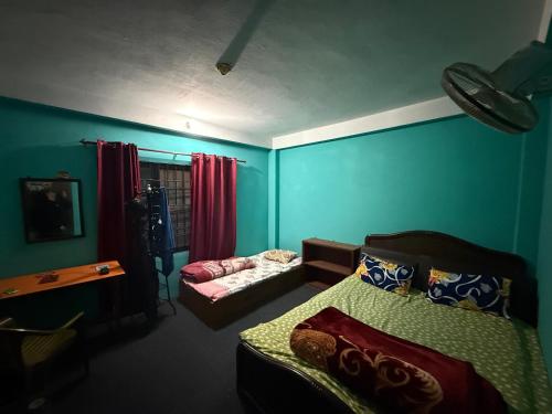 a bedroom with blue walls and a bed and a couch at The Kapil Homestay in Manamaiju