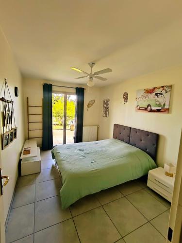 een slaapkamer met een groot bed en een groen dekbed bij T2 avec terrasse & garage privé, Proche Jaude in Chamalières