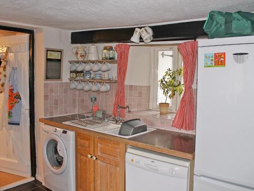 a kitchen with a sink and a washing machine at Elm Cottage in Beckermonds