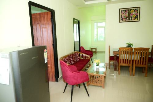 a living room with a red couch and a table at OZY Homestay in Rāiwāla