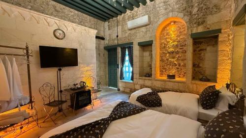 a bedroom with two beds and a flat screen tv at Liora Hotel in Sanlıurfa