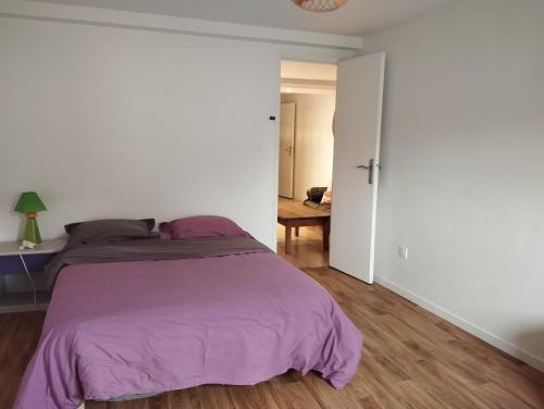 a bedroom with a bed with a purple blanket at Appartement Saint Sulpice la Pointe in Saint-Sulpice