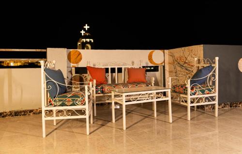 two chairs and a table on a balcony at night at Christmas Arabic Escape Roof Terrace 3 Bedroom Luxury Appartment Superb Location and just 15 mins from El Gouna in Hurghada