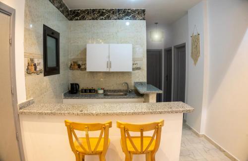 two yellow chairs sitting at a kitchen counter at Christmas Arabic Escape Roof Terrace 3 Bedroom Luxury Appartment Superb Location and just 15 mins from El Gouna in Hurghada