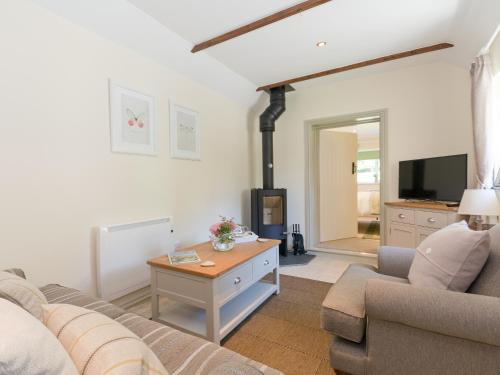 ein Wohnzimmer mit Sofa und Fernseher in der Unterkunft Cherry Blossom in Thornton Dale