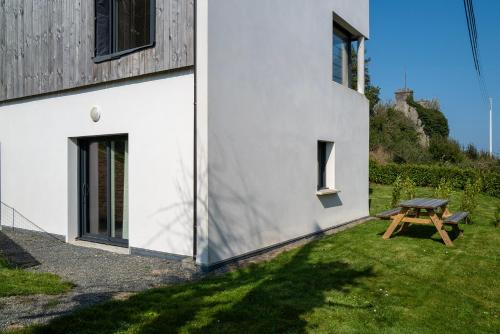 a picnic table in a yard next to a building at Appartement Neuf - Port de l'AberWrac'h - in Landéda