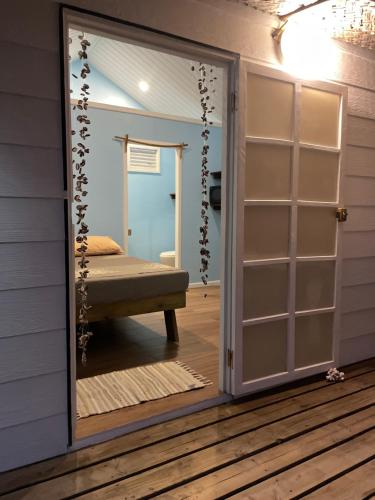 uma porta que leva a um quarto com uma cama num quarto em Tetaha Lodge em Tiputa
