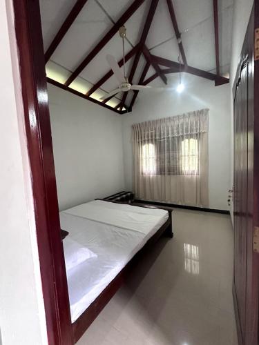 a bedroom with a bed and a ceiling fan at Yasiru Villa in Weligama