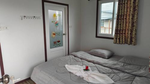 Un dormitorio con una cama con una toalla encima. en Koh Libong Maldives Homestay, 