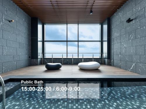 two pillows sitting on a bench in a room with a large window at Mitsui Garden Hotel Toyosu Premier - Tokyo in Tokyo
