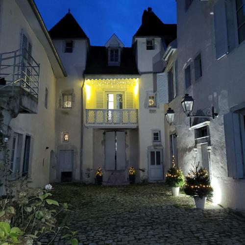 une cour intérieure d'un immeuble avec un balcon la nuit dans l'établissement Le cocon particulier, à Lons-le-Saunier