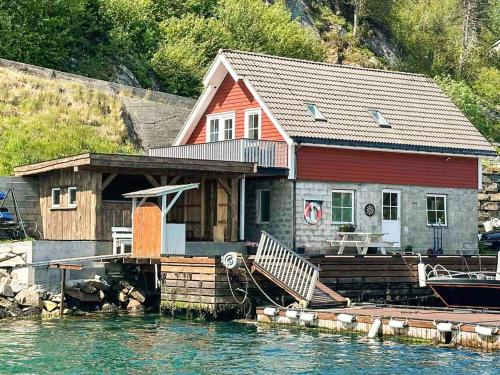 a house on a dock with a boat in the water at 4 person holiday home in Urangsvåg-By Traum in Ervik