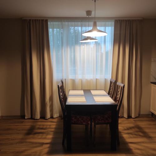 a dining room table with chairs in front of a window at Tammiste Holiday House in Tammiste