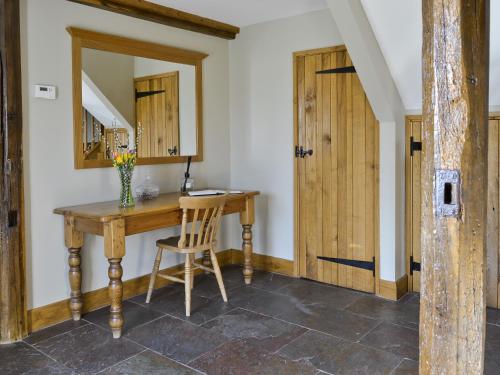 UggeshallにあるThe Granary-E3567の木製デスクと鏡が備わる客室です。