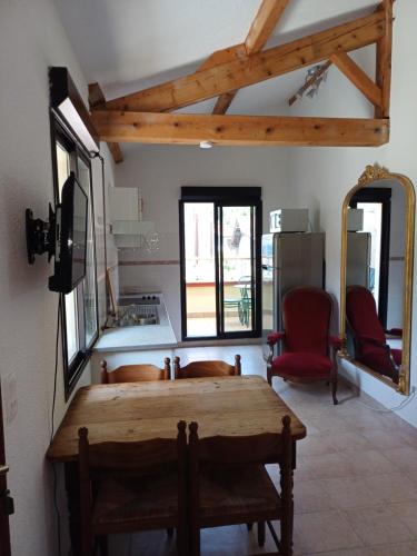 Mauléon-BarousseにあるLes Suites de Mauléonの木製テーブルと赤い椅子2脚が備わる客室です。
