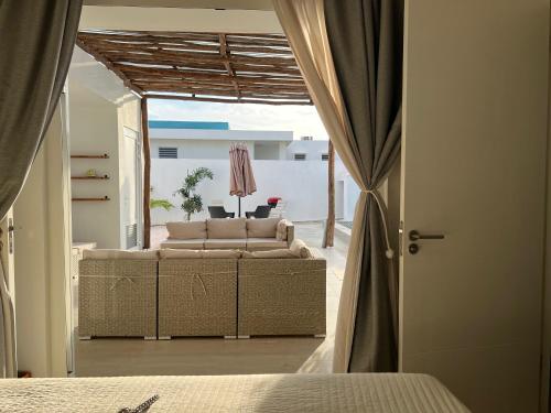 een woonkamer met een bank en een raam bij Casa Wechi in Willemstad