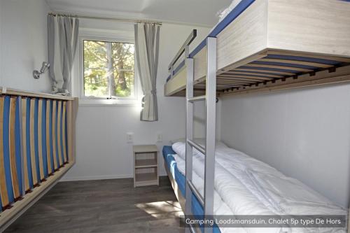 a bedroom with a bunk bed and a window at Camping Loodsmansduin in Den Hoorn