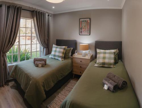 a bedroom with two beds and a window at Welverdiend - Unit 2 in Bloemfontein