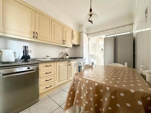 een keuken met een tafel met een polka dot tafelkleed bij Lido Funchal in Funchal